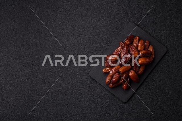 Dried dates on a ceramic plate for Ramadan or Iftar. Dried dates as a food background for your design