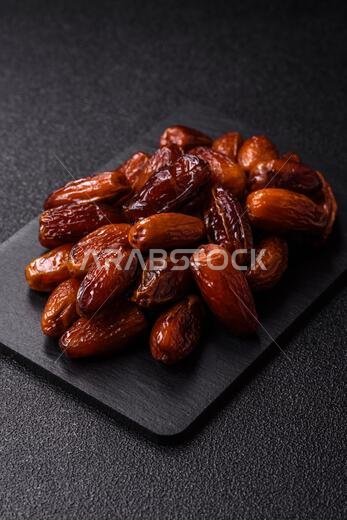 Dried dates on a ceramic plate for Ramadan or Iftar. Dried dates as a food background for your design