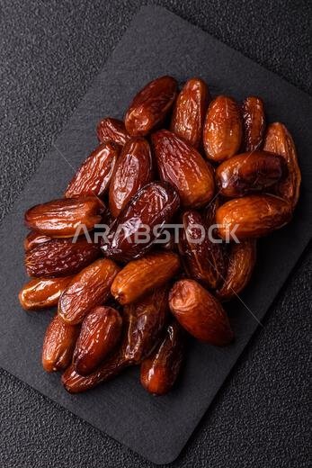 Dried dates on a ceramic plate for Ramadan or Iftar. Dried dates as a food background for your design