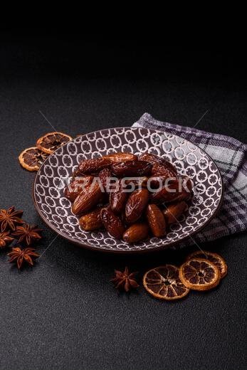 Dried dates on a ceramic plate for Ramadan or Iftar. Dried dates as a food background for your design