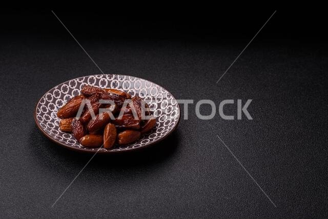 Dried dates on a ceramic plate for Ramadan or Iftar. Dried dates as a food background for your design