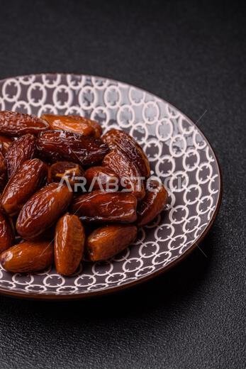 تمر مجفف على طبق خزفي لرمضان أو الإفطار. التمر المجفف كخلفية طعام لتصميمك