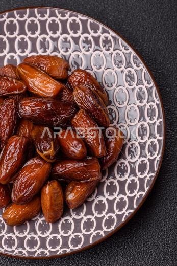 تمر مجفف على طبق خزفي لرمضان أو الإفطار. التمر المجفف كخلفية طعام لتصميمك