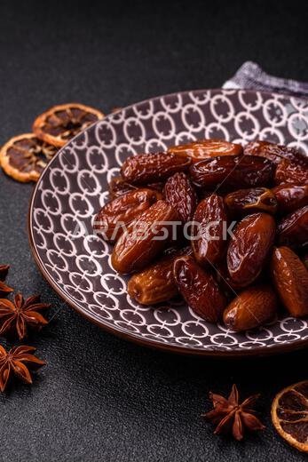 تمر مجفف على طبق خزفي لرمضان أو الإفطار. التمر المجفف كخلفية طعام لتصميمك