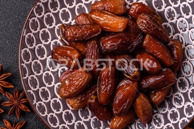 Dried dates on a ceramic plate for Ramadan or Iftar. Dried dates as a food background for your design