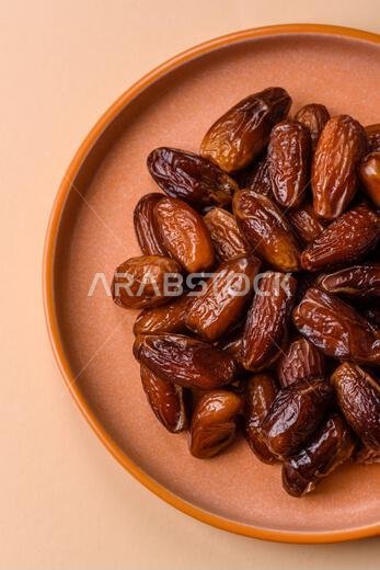 تمر مجفف على طبق خزفي لرمضان أو الإفطار. التمر المجفف كخلفية طعام لتصميمك