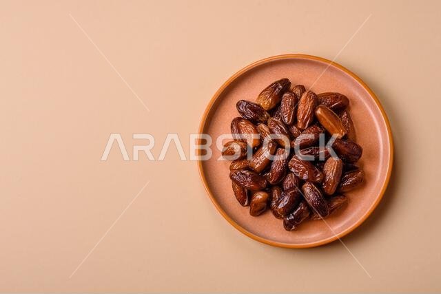 تمر مجفف على طبق خزفي لرمضان أو الإفطار. التمر المجفف كخلفية طعام لتصميمك