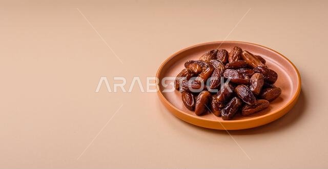 تمر مجفف على طبق خزفي لرمضان أو الإفطار. التمر المجفف كخلفية طعام لتصميمك تمر مجفف على طبق خزفي لرمضان أو الإفطار. التمر المجفف كخلفية طعام لتصميمك