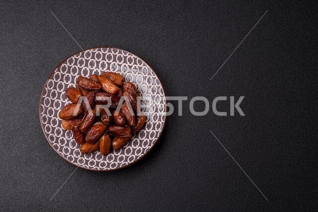 Dried dates on a ceramic plate for Ramadan or Iftar. Dried dates as a food background for your design