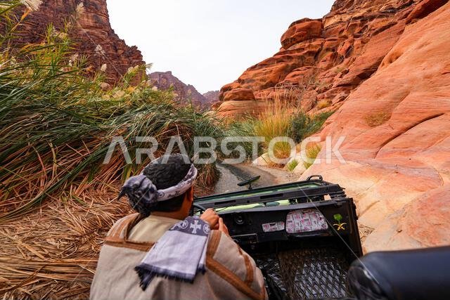 سائق تقليدي يستكشف وادي الديسة المذهل في سيارة دفع رباعي مكشوفة بالقرب من تبوك في المملكة العربية السعودية