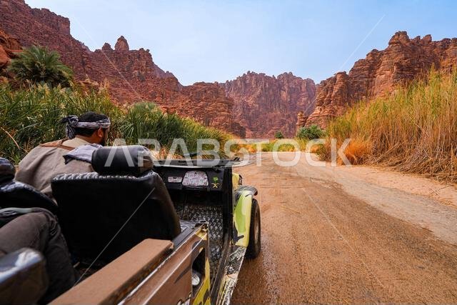 سائق تقليدي يستكشف وادي الديسة المذهل في سيارة دفع رباعي مكشوفة بالقرب من تبوك في المملكة العربية السعودية
