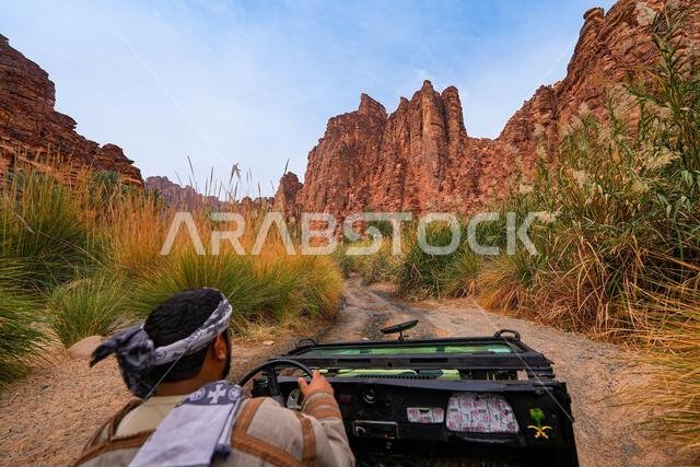 سائق تقليدي يستكشف وادي الديسة المذهل في سيارة دفع رباعي مكشوفة بالقرب من تبوك في المملكة العربية السعودية