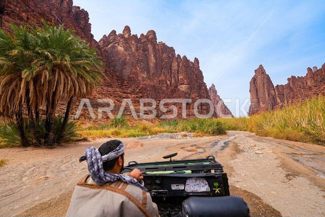 سائق تقليدي يستكشف وادي الديسة المذهل في سيارة دفع رباعي مكشوفة بالقرب من تبوك في المملكة العربية السعودية