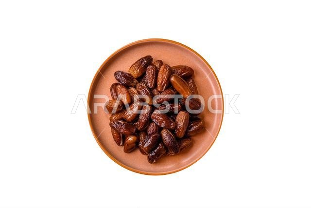 تمر مجفف على طبق خزفي لرمضان أو الإفطار. التمر المجفف كخلفية طعام لتصميمك تمر مجفف على طبق خزفي لرمضان أو الإفطار. التمر المجفف كخلفية طعام لتصميمك