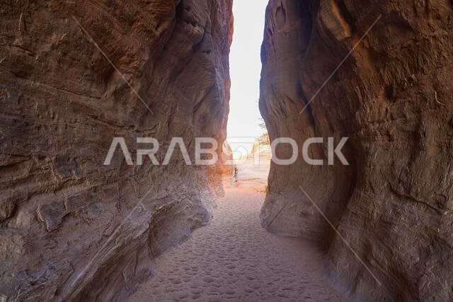 The spectacular entrance of the Siq, a natural canyon passage between sandstone cliffs at the ancient Nabataean sanctuary of Jabal Ithlib in Hegra, Al