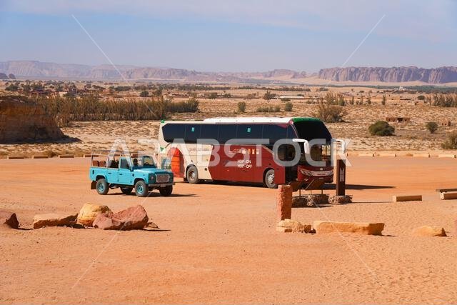Modern Hop-On Hop-Off tourist bus in the desert surrounding Hegra in AlUla, Saudi Arabia