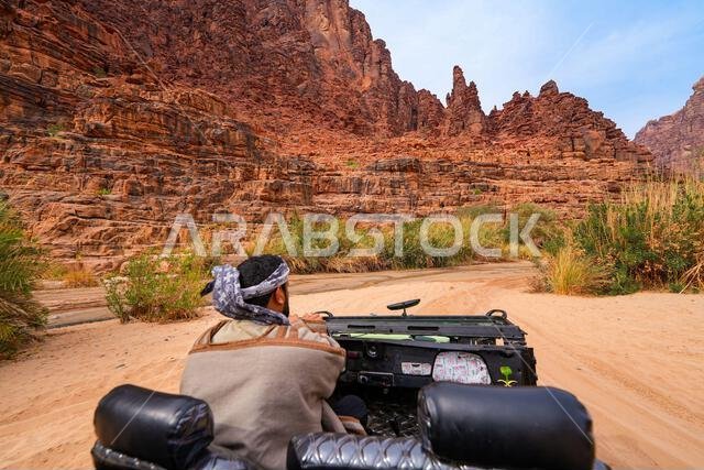 Traditional driver exploring the spectacular Wadi Al Disah canyon in an open-top 4x4 near Tabuk in Saudi Arabia