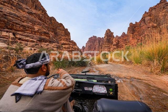 سائق تقليدي يستكشف وادي الديسة المذهل في سيارة دفع رباعي مكشوفة بالقرب من تبوك في المملكة العربية السعودية