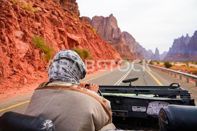 سائق تقليدي يستكشف وادي الديسة المذهل في سيارة دفع رباعي مكشوفة بالقرب من تبوك في المملكة العربية السعودية