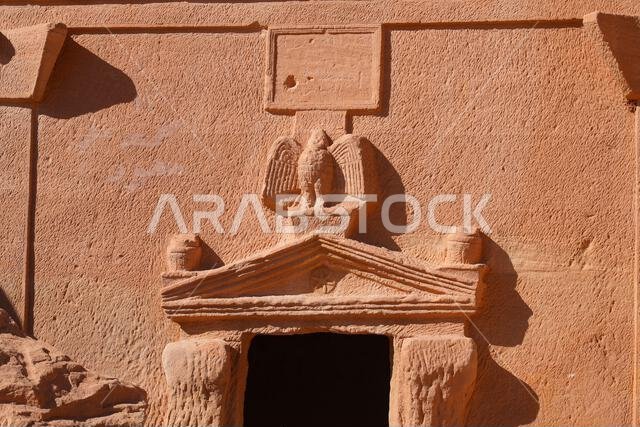 Close-up of a carved Nabataean eagle and inscription panel on a tomb of Jabal AlBanat in Hegra, AlUla, Saudi Arabia Close-up of a carved Nabataean eagle and inscription panel on a tomb of Jabal AlBanat in Hegra, AlUla, Saudi Arabia