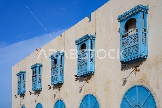 نوافذ مشربية زرقاء تقليدية في سوق العامرة الذي تم ترميمه في أملج، المملكة العربية السعودية