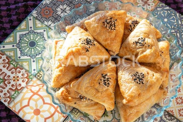 Samosa food made from puff pastry dough. A triangular pie with meat filling with sesame seeds. Asian food. Plate top view