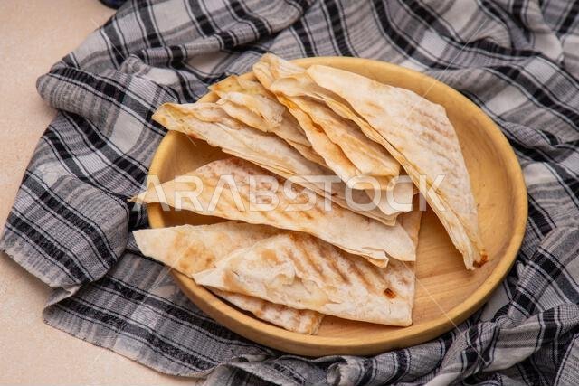 المطباق، وهو خبز مسطح مثلث الشكل مصنوع من عجين رقيق محشو ومقلي في مقلاة، يُعد من الأطعمة العربية التقليدية.