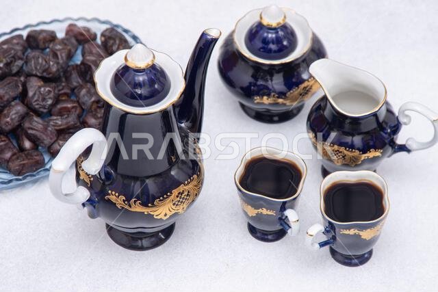Coffee set with decanter, creamer, blue sugar bowl and cups . Vintage tableware. Sweet dates fruit.