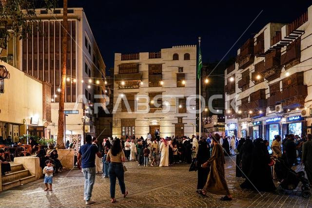 حشد من الناس يستمتعون بأمسية في ساحة عامة في جدة القديمة، المملكة العربية السعودية حشد من الناس يستمتعون بأمسية في ساحة عامة في جدة القديمة، المملكة العربية السعودية