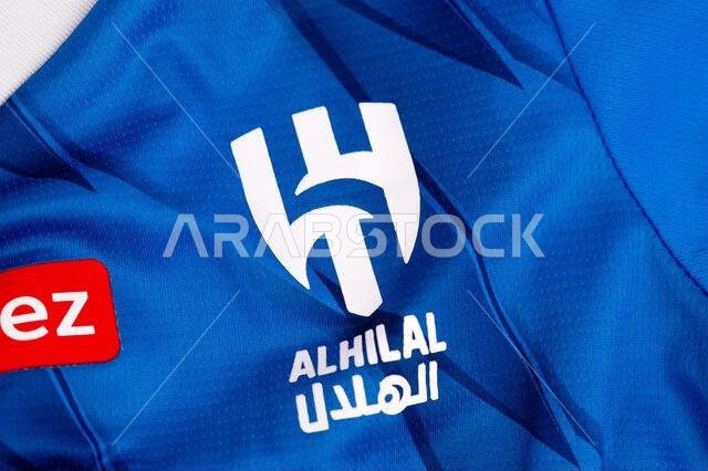 كييف، أوكرانيا. 4 فبراير 2026. صورة مقرّبة لشعار نادي الهلال لكرة القدم على قماش قميص أزرق، تُظهر العلامة التجارية الرياضية وهوية الفريق.