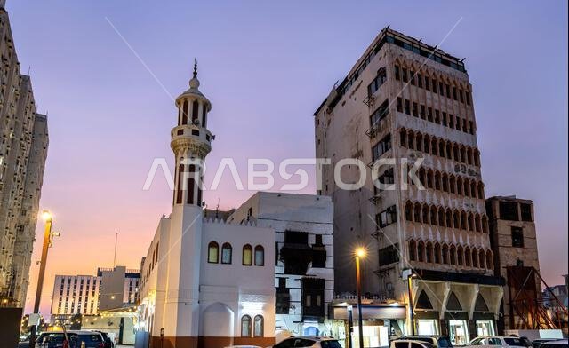 منظر للعمارة التقليدية ومئذنة المسجد في حي البلد التاريخي بجدة عند غروب الشمس، المملكة العربية السعودية. منظر للعمارة التقليدية ومئذنة المسجد في حي البلد التاريخي بجدة عند غروب الشمس، المملكة العربية السعودية.