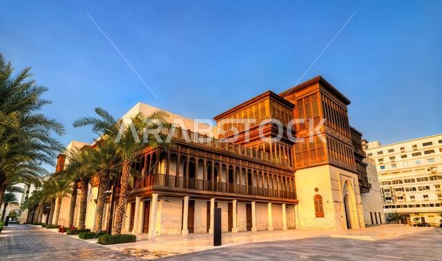 Beautiful restoration of traditional wooden balconies and stonework at Culture Square of Jeddah under a clear blue sky in Saudi Arabia.