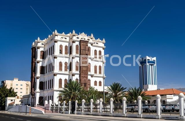 The historic Shubra Palace museum features traditional Hijazi architecture with ornate wooden windows under a clear blue sky in Taif, Saudi Arabia. The historic Shubra Palace museum features traditional Hijazi architecture with ornate wooden windows under a clear blue sky in Taif, Saudi Arabia.
