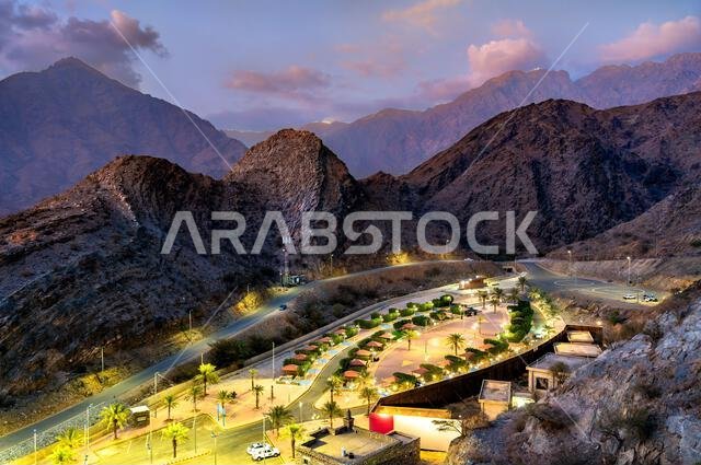 منظر علوي لحديقة ذي عين المضاءة المحاطة بجبال السروات عند الغسق في الباحة، المملكة العربية السعودية