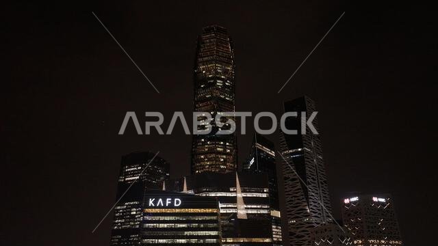 Night view of King Abdullah Financial District in Riyadh, Saudi Arabia, featuring illuminated skyscrapers and modern urban architecture.