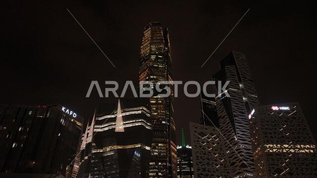 Night view of King Abdullah Financial District in Riyadh, Saudi Arabia, featuring illuminated skyscrapers and modern urban architecture.