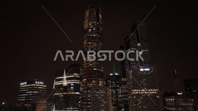 Night view of King Abdullah Financial District in Riyadh, Saudi Arabia, featuring illuminated skyscrapers and modern urban architecture.