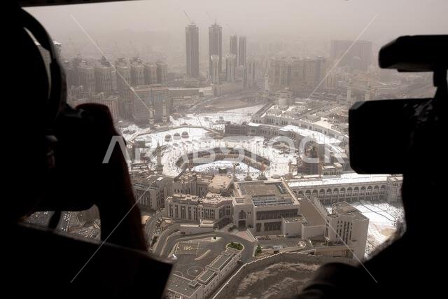 التقط مصوران صورة لمدينة مغطاة بالثلوج من نافذة طائرة هليكوبتر تطل على ساحة مفتوحة كبيرة.