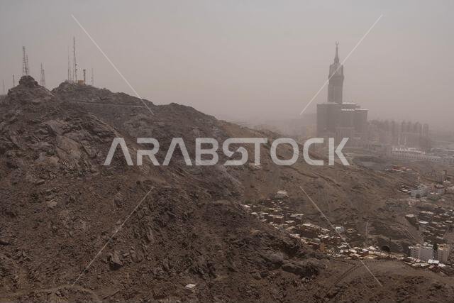 A dusty hillside dominates the foreground, while the iconic Royal Opera House rises in the hazy distance.