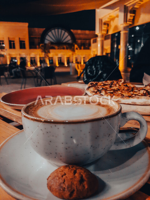  صوره مقربه لفنجان قهوه  مع قطع الكوكيز اللذيذه,  قهوة اسبرسو داكنه, رقائق البسكويت بالشوكولاته