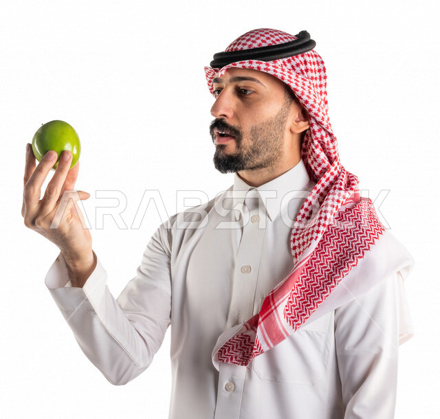 بورتريه لرجل عربي سعودي خليجي يحمل بيده فواكه صحيه شهيه, تناول وجبة طعام صحيه خفيفه, وجبات الدايت, الصحه والرشاقه, خدمات توصيل الطعام, طلب واستلام الديليفري, خدمات منزليه, توصيل طلبات الطعام, خلفيه بيضاء