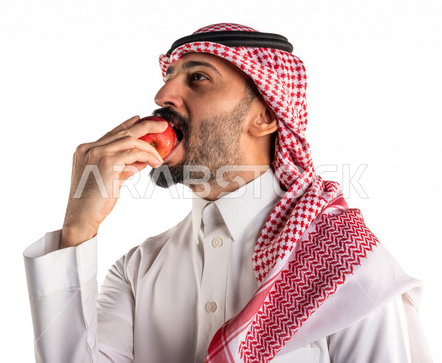 بورتريه لرجل عربي سعودي خليجي يحمل بيده فواكه صحيه شهيه, تناول وجبة طعام صحيه خفيفه, وجبات الدايت, الصحه والرشاقه, خدمات توصيل الطعام, طلب واستلام الديليفري, خدمات منزليه, توصيل طلبات الطعام, خلفيه بيضاء