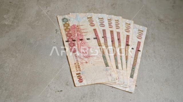 Saudi riyals placed on a concrete surface illustrating wealth, finance, commerce, and middle eastern currency in six arranged banknotes from saudi ara