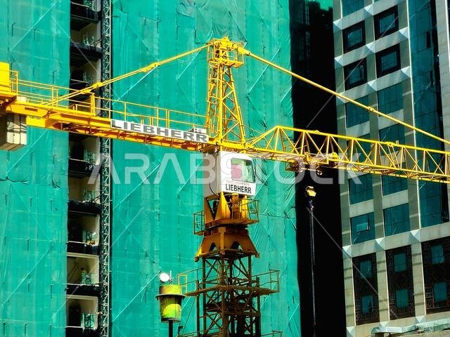 Medina, Saudi Arabia, June 27 2024: A construction site of a new high skyscraper building in Madinah city with a Liebherr crane tower at the construct