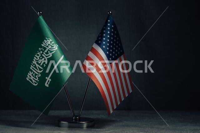 Table flags United States America and National Flag Saudi Arabia on dark background,political concept