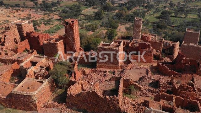 صورة جوية لمنازل مبنية من الحجر الأحمر والطين مع أسقف من الأردواز في قرية بمنطقة عسير، سرات عبيدة، المملكة العربية السعودية