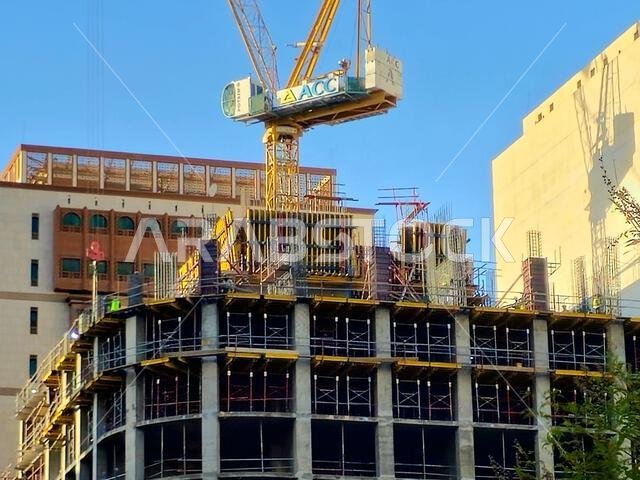 Medina, Saudi Arabia, June 26 2024: a new high building in Madinah city that is under construction, with a crane tower of ACC Arabian Construction Com Medina, Saudi Arabia, June 26 2024: a new high building in Madinah city that is under construction, with a crane tower of ACC Arabian Construction Com