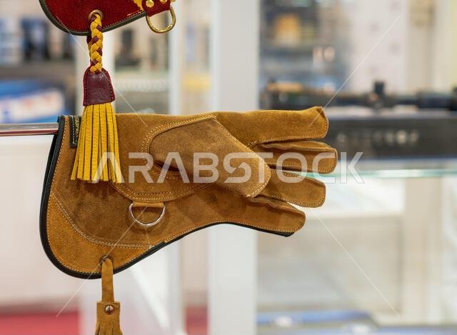 الدوحة، قطر - 27 سبتمبر 2024: مجموعة من قفازات الصيد بالصقور معروضة في أحد أكشاك السوق، تُبرز الحرفية والتنوع المصمم خصيصًا لها. الدوحة، قطر - 27 سبتمبر 2024: مجموعة من قفازات الصيد بالصقور معروضة في أحد أكشاك السوق، تُبرز الحرفية والتنوع المصمم خصيصًا لها.