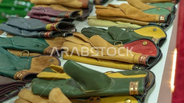 الدوحة، قطر - 27 سبتمبر 2024: مجموعة من قفازات الصيد بالصقور معروضة في أحد أكشاك السوق، تُبرز الحرفية والتنوع المصمم خصيصًا لها. الدوحة، قطر - 27 سبتمبر 2024: مجموعة من قفازات الصيد بالصقور معروضة في أحد أكشاك السوق، تُبرز الحرفية والتنوع المصمم خصيصًا لها.