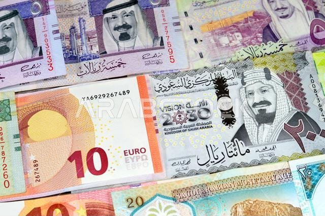 العملات الأوروبية: اليورو (EUR) والريال السعودي (SAR)، عملات ورقية من الريال السعودي بقيم مختلفة، تعكس الوضع الاقتصادي للعملة.